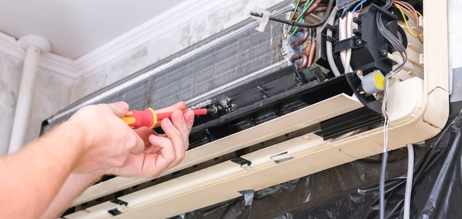 a man disassembles an air conditioner for repair a